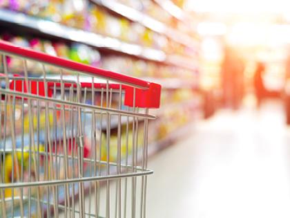 Photo of shopping cart in aisle in grocery store