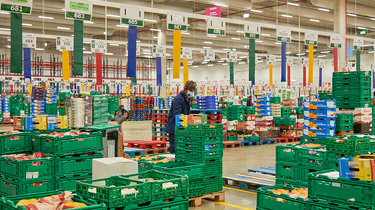 A retail warehouse with many items on a colorful array of shipping palets