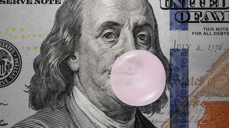 Tight shot of a $100 bill with Benjamin Franklin blowing a bubble of pink bubble gum