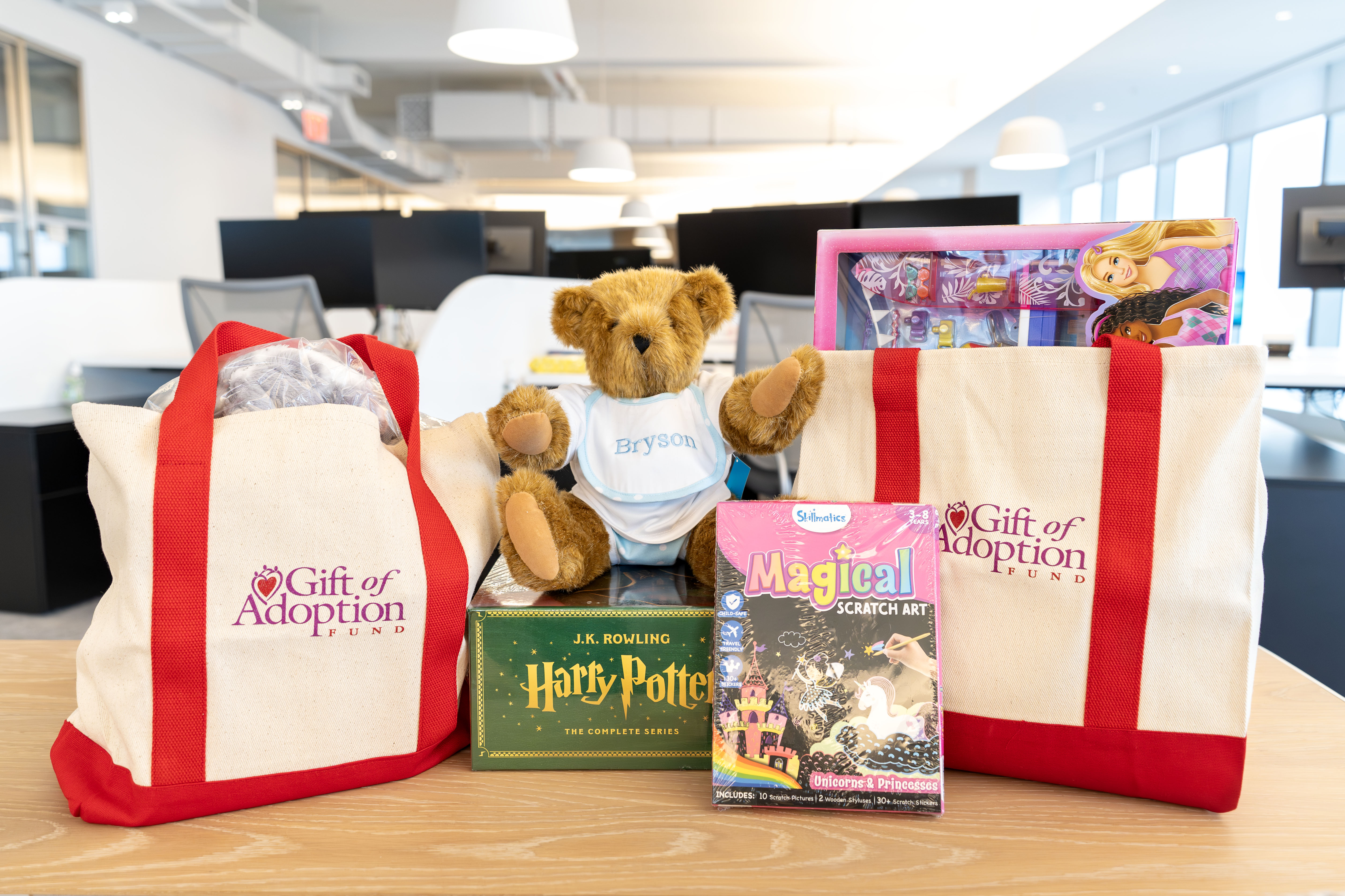 Two tote bags filled with gifts next to a teddy bear.