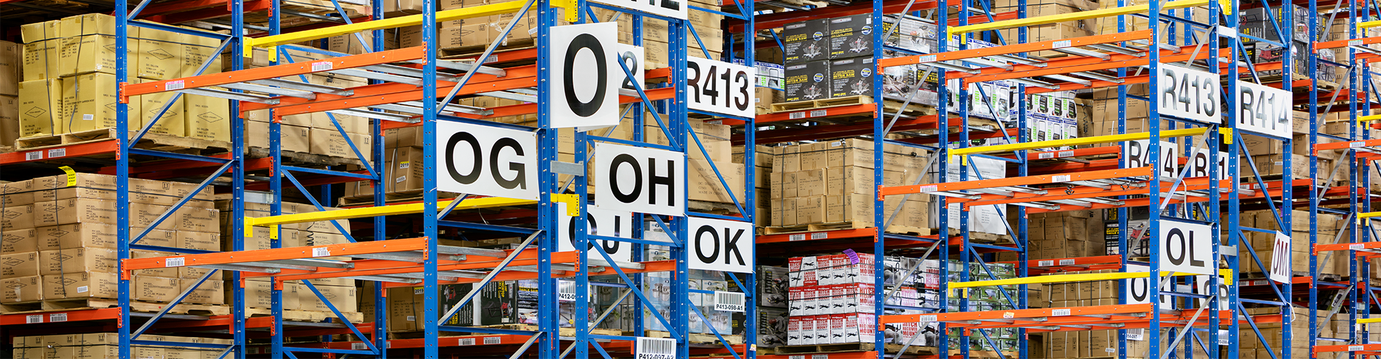 Shelves leading up to the ceiling stacked with cardboard boxes in a warehouse