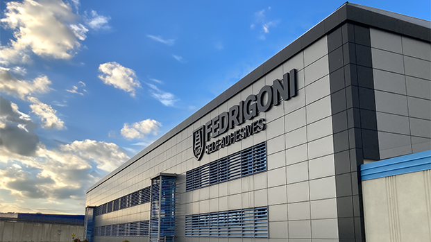 A warehouse leased to Fedrigoni, owned by W. P. Carey, against a blue sky with clouds.