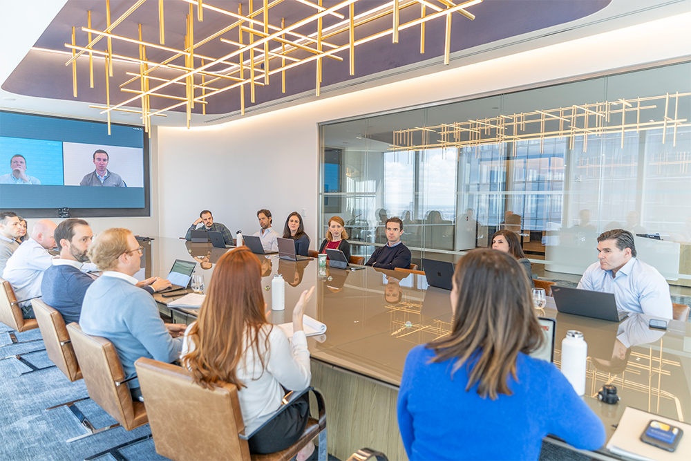 Members of the W. P Carey team sitting around the conference table in the board room at the company's NYC headquarters.