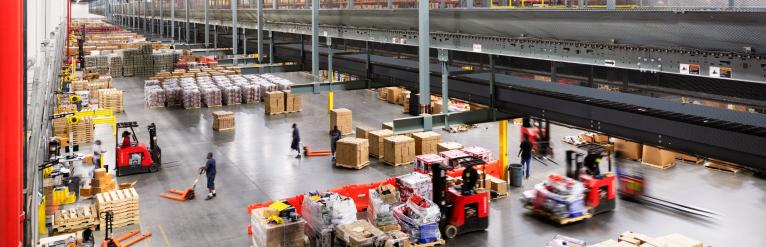 Inside a busy warehouse with lots of cardboard boxes and employees, owned by W. P. Carey
